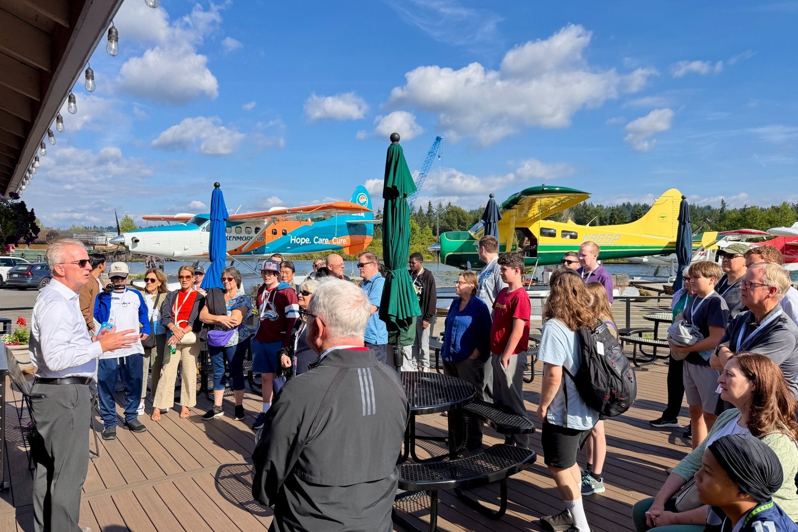 Aviation Expo attendees gathered at Kenmore Air with seaplanes behind them